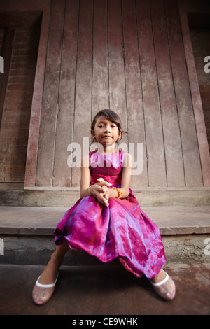 Portrait of cute Asian female enfant en robe rose looking at camera Banque D'Images