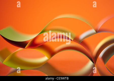 Fond d'une image de modèle d'origami coloré fait de feuilles de papier, sur fond orange Banque D'Images