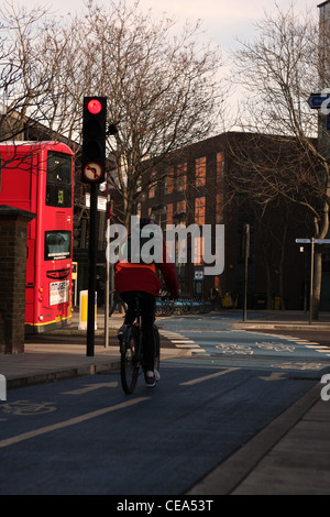 Un cycliste sur un cycle superhighway approchant les feux rouges Banque D'Images