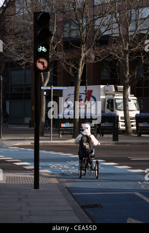 Un tricycle rider sur un cycle superhighway équitation par feu vert Banque D'Images