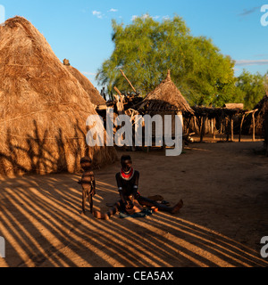 Karo femme et bébé assis au milieu de huttes Karo Vallée de l'Omo en Ethiopie Banque D'Images