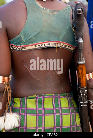 Dos de Femme Banna flagellées précédemment portant Kalachnikov Bull Cérémonie Vallée de l'Omo Ethiopie Saut Banque D'Images