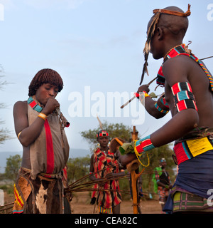 Is Woman Blowing une corne lors de l'obtention flagellées Bull Cérémonie Saut Vallée de l'Omo en Ethiopie Banque D'Images