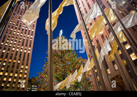 Arbre de Noël entouré de drapeaux d'or et d'argent au Rockefeller Center, New York Banque D'Images