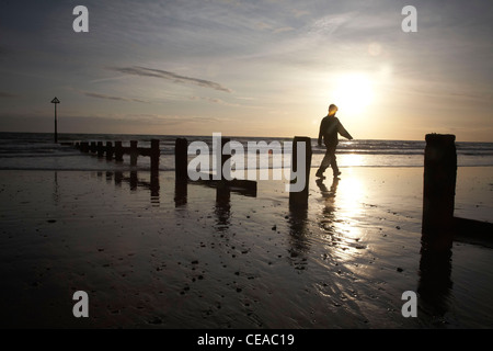 Silhouette de personne sur la plage de Barmouth et pendant le coucher du soleil. Banque D'Images