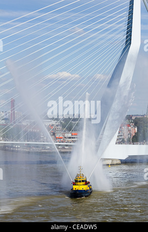 Firefightingboat démonstration sur la rivière de jets d'eau de pulvérisation avec Erasmus, Rotterdam, Pays-Bas en arrière-plan. Banque D'Images