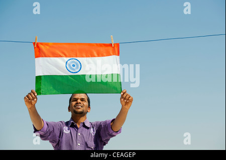 L'homme Indien tenant un drapeau indien sur un lave-ligne. L'Andhra Pradesh, Inde Banque D'Images