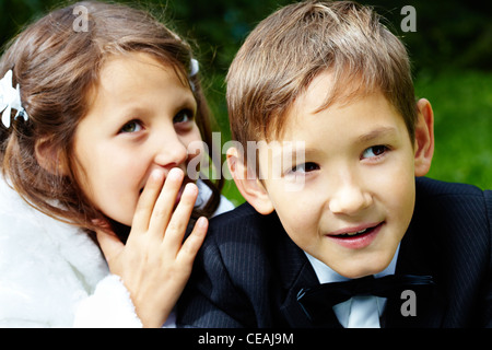 Portrait of boy marié à côté avec son épouse pour lui dire un secret Banque D'Images
