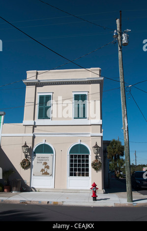 Drummond Community Bank Building sur 2nd Street, Cedar Key Center, Floride, États-Unis. Architecture historique avec volets verts et fenêtres cintrées. Banque D'Images