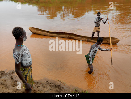 Karo Karo poitrine peint en blanc, l'un des hommes dans une pirogue sur la rivière Pôle Holding Ethiopie Banque D'Images