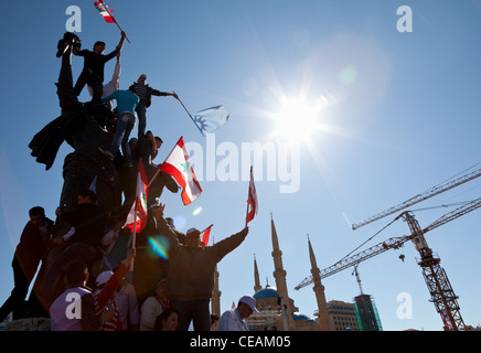 Partisans politiques avec les drapeaux escalader monument Place des Martyrs à Beyrouth au Liban durant le printemps arabe de 2011. Low angle Banque D'Images