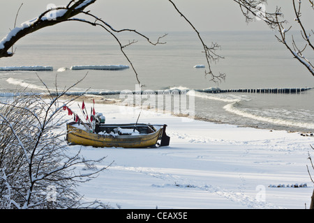 Bateau de pêche sur la plage à Rewal, sur la côte ouest de la mer Baltique en Pologne. L'hiver sur la mer Baltique Banque D'Images