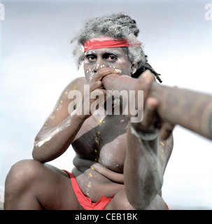 L'homme jouant un didgeridoo autochtones sur une plage. Banque D'Images