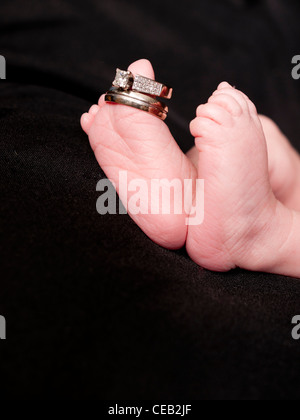 Un nouveau-né les pieds ont des bandes de mariage de ses parents sur ses orteils. Banque D'Images