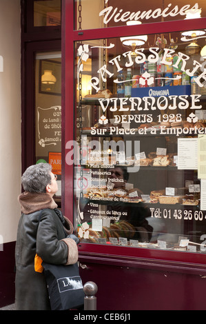 Une femme en face d'une fenêtre du boulanger à Montmartre, Paris Banque D'Images