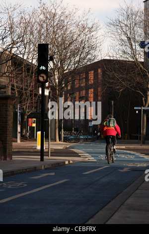 Un cycliste voyageant passé feux de circulation sur un cycle superhighway à Londres Banque D'Images