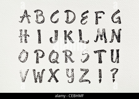 Alphabet de tampon en caoutchouc imprimé en encre noire sur toile d'artiste blanc Banque D'Images