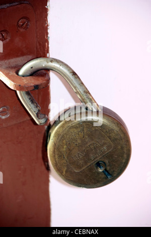 Une vieille serrure rouillée accrochée au mur porte en crochet Banque D'Images