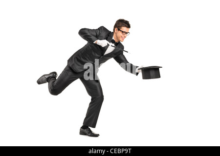 Portrait d'un magicien avec une baguette magique et gesticulant isolé sur fond blanc Banque D'Images