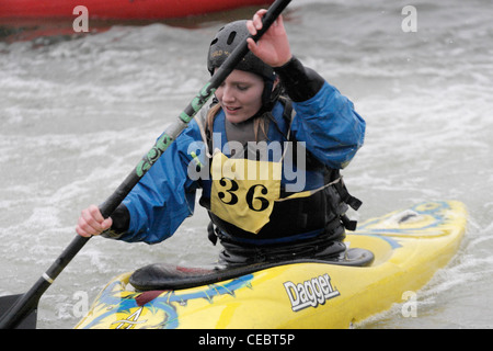 Femme fille canoéiste prenant part à la concurrence inter university sur la rivière Exe Exeter 4/2/12 Tournage sur un barrage Banque D'Images