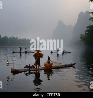 Les pêcheurs cormorant en radeaux de bambou au lever du soleil sur la rivière li avec des pics karstiques près de xingping chine Banque D'Images