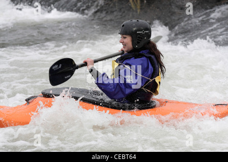 Femme fille canoéiste prenant part à la concurrence inter university sur la rivière Exe Exeter 4/2/12 Tournage sur un barrage Banque D'Images