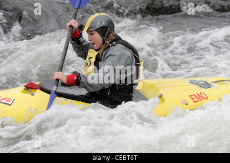 Femme fille canoéiste prenant part à la concurrence inter university sur la rivière Exe Exeter 4/2/12 Tournage sur un barrage Banque D'Images