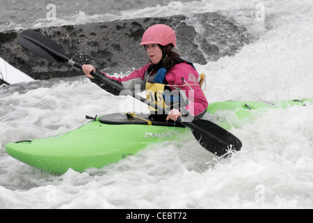 Femme fille canoéiste prenant part à la concurrence inter university sur la rivière Exe Exeter 4/2/12 Tournage sur un barrage Banque D'Images