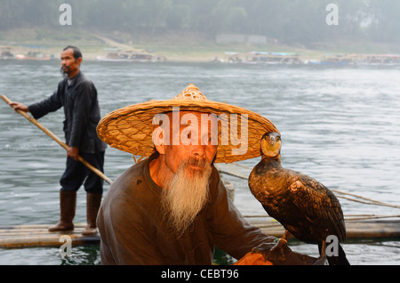 Le Cormorant fisherman holding bird et un autre bassin pour enfants passé sur la rivière Lijiang Li ou Xingpingzhen près de Yangshuo, Guilin, Guangxi, Chine Banque D'Images