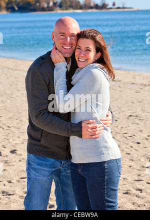 Beau jeune couple hugging at la plage en hiver Banque D'Images