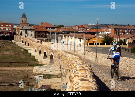 Cycliste sur le Chemin de Saint-Jacques à travers la ville de Hospital de Orbigo Banque D'Images