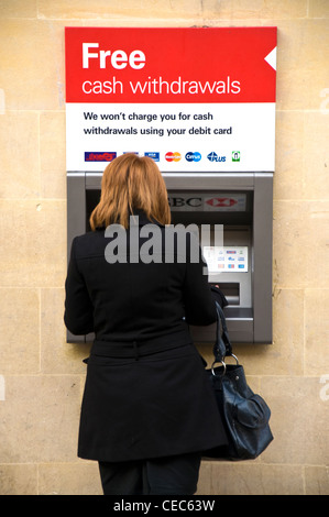 Femme avec sac à main en noir au guichet automatique machine distributeur Banque D'Images