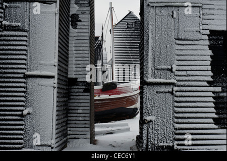 Bateau de pêche et huttes net dans la neige. Le Stade. Hastings. East Sussex. L'Angleterre. UK Banque D'Images