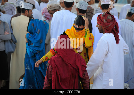 Contraire de noir vêtues les femmes de sud de l'Oman, Bedu tribeswomen portent des robes de couleur à Nizwa, Oman marché de la chèvre Banque D'Images