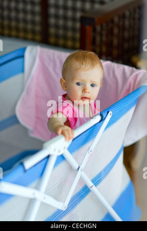 Bébé debout dans un parc pour enfants Banque D'Images