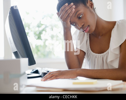 Frustrés Black businesswoman working at desk Banque D'Images