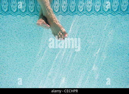 Caucasian woman's pieds sous l'eau à la piscine Banque D'Images