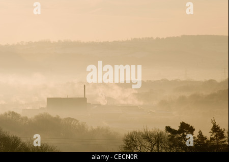 Voir plus haut Esholt au traitement des eaux usées (égouts) niché dans la vallée boisée, sur misty gris et froid matin d'hiver - West Yorkshire, Angleterre, Royaume-Uni. Banque D'Images