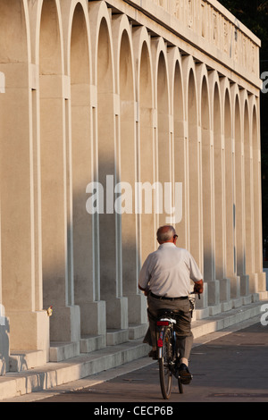 Un cycliste passe par l'architecture rationaliste de Tresigallo Province de Ferrare Emilia-Romagna Italie Banque D'Images