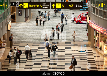 Les passagers à pied à travers le hall de transit de l'aérogare 3 à l'aéroport de Changi à Singapour Banque D'Images