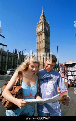 L'Angleterre, Londres, jeune couple de touristes à Londres à la carte en face de Big Ben Westminster Banque D'Images