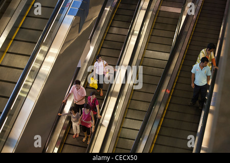 Les gens monter un tapis roulant à l'aéroport de Changi à Singapour Banque D'Images