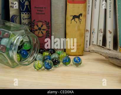 Livres pour enfants vintage et un pot de billes sur une étagère en bois Banque D'Images