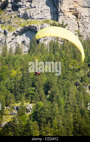 Vue verticale de parapente en tandem sur le point d'atterrir sur une journée ensoleillée. Banque D'Images