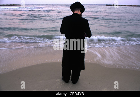 L'homme juif ultra-orthodoxes prient le long de la mer Méditerranée dans la ville israélienne de Tel Aviv, tout en effectuant le rituel 'Tachlikh' au cours de laquelle 'sins sont exprimés dans l'eau pour le poisson". L 'Tachlikh' rituel est effectué avant le jour de l'Expiation, ou Yom Kippour, le jour le plus important dans le calendrier juif Banque D'Images