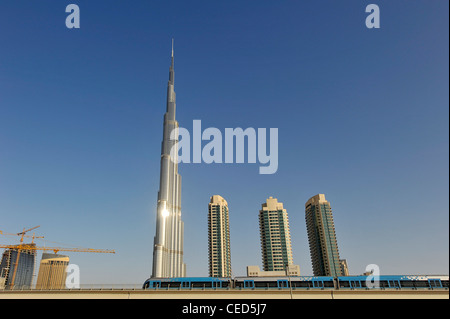 Le métro et le Burj Khalifa, la tour la plus haute du monde, 828m de hauteur, dans le soleil du soir, le centre-ville de Dubaï, aux Émirats Arabes Unis Banque D'Images