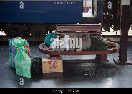 Man Sleeping sur banc de la plate-forme de la gare Hualamphong Bangkok Thaïlande Banque D'Images