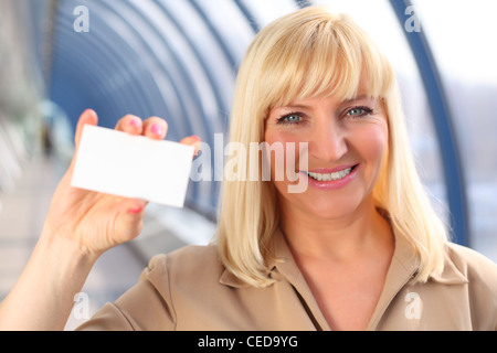 Smiling businesswoman d'âge moyen carte montre Banque D'Images