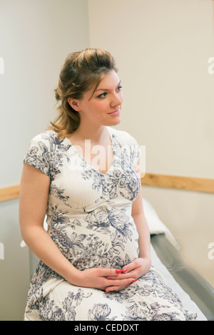 Portrait de jeune femme enceinte au bureau de médecins. Banque D'Images