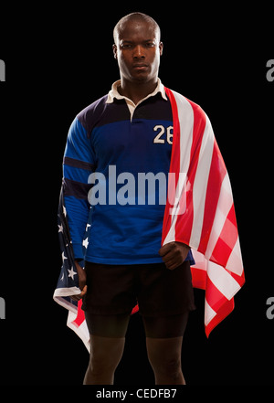 African American rugby player enveloppée de drapeau américain Banque D'Images